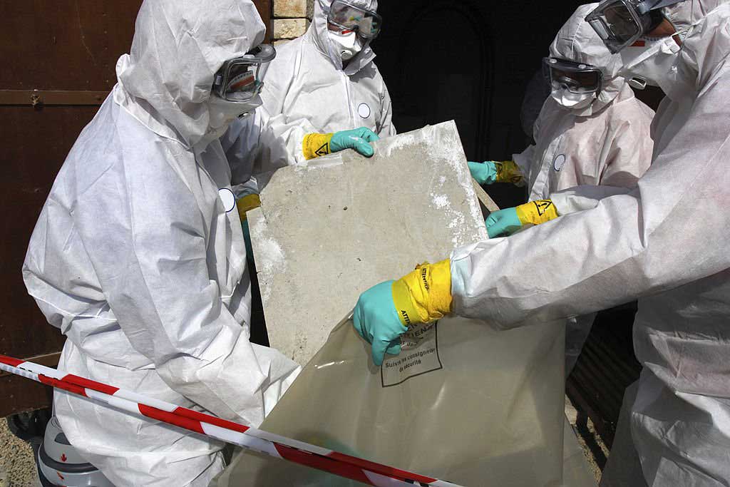 Equipe en combinaison de protection manipulant un panneau contenant de lamiante a Bruxelles – grondwerken en afbraakwerken door ARS
