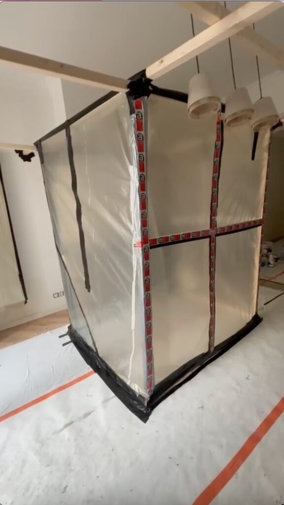 Afgesloten ruimte met plastic folie tijdens binnenwerk voor asbestverwijdering om verspreiding van asbestvezels te voorkomen. Diagnose asbest vóór werken in woning.